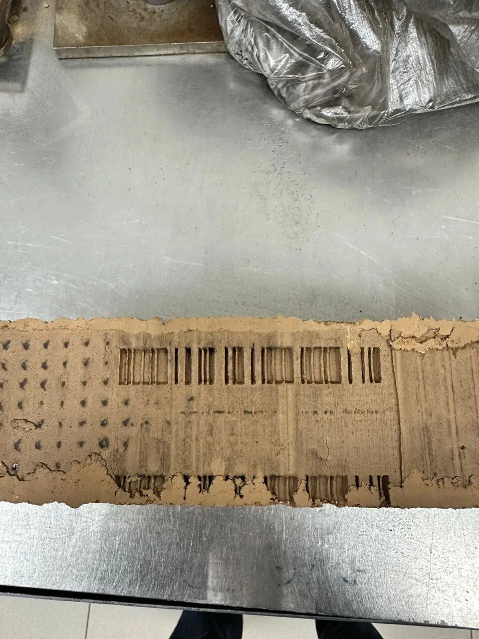 Cut of a wet clay column with a code imprint